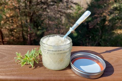 a jar of sugar scrub with a spoon sticking out of it