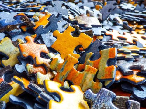 Multi-colored puzzle pieces in a big pile.