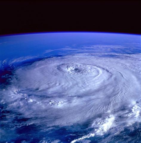 Image of a massive hurricane as seen from space. There are swirling cloud formations characteristic of a hurricane, with a clearly defined eye at the center.