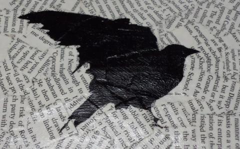 Image of a bird silhouette painted black on a collage of overlapping book text.