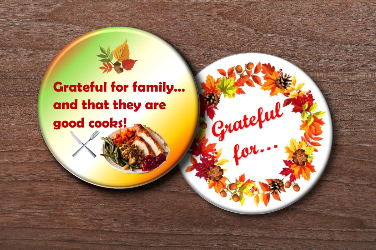 two button pins in fall colors, one saying "Grateful for..." and one saying "Grateful for family...and that they are good cooks."