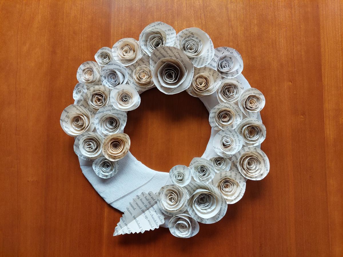 Wreath decorated with rolled roses made from recycled book pages.